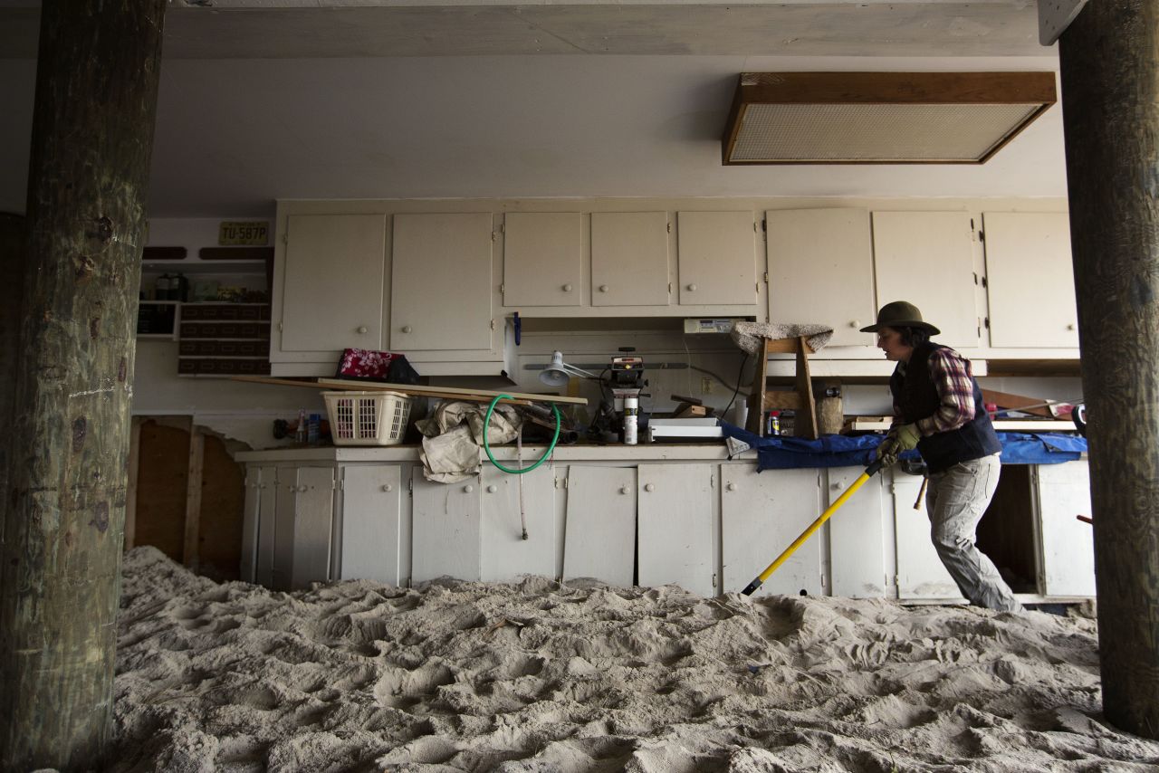 Amy Neukom works to remove sand from her parents' house in Mantoloking, New Jersey, on Friday -- a result of Superstorm Sandy.