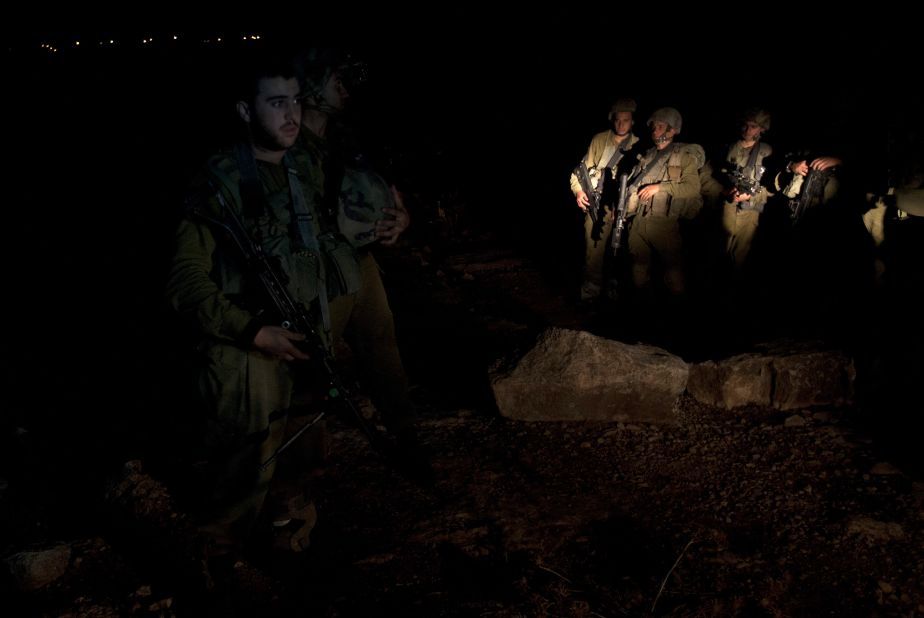 Israeli soldiers stand guard while explosives experts examine the site where a rocket fired from the Gaza Strip landed near the Jewish settlement of Gush Etzion in the village of Kisan, south of Bethlehem on Friday, November 16.
