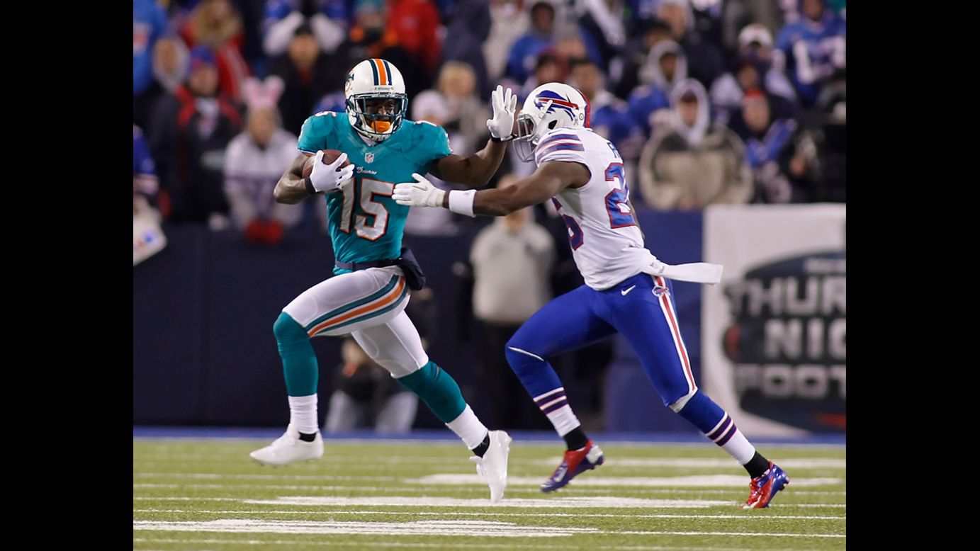 Davone Bess, left, of the Miami Dolphins stiff-arms Justin Rogers of the Buffalo Bills on Thursday.