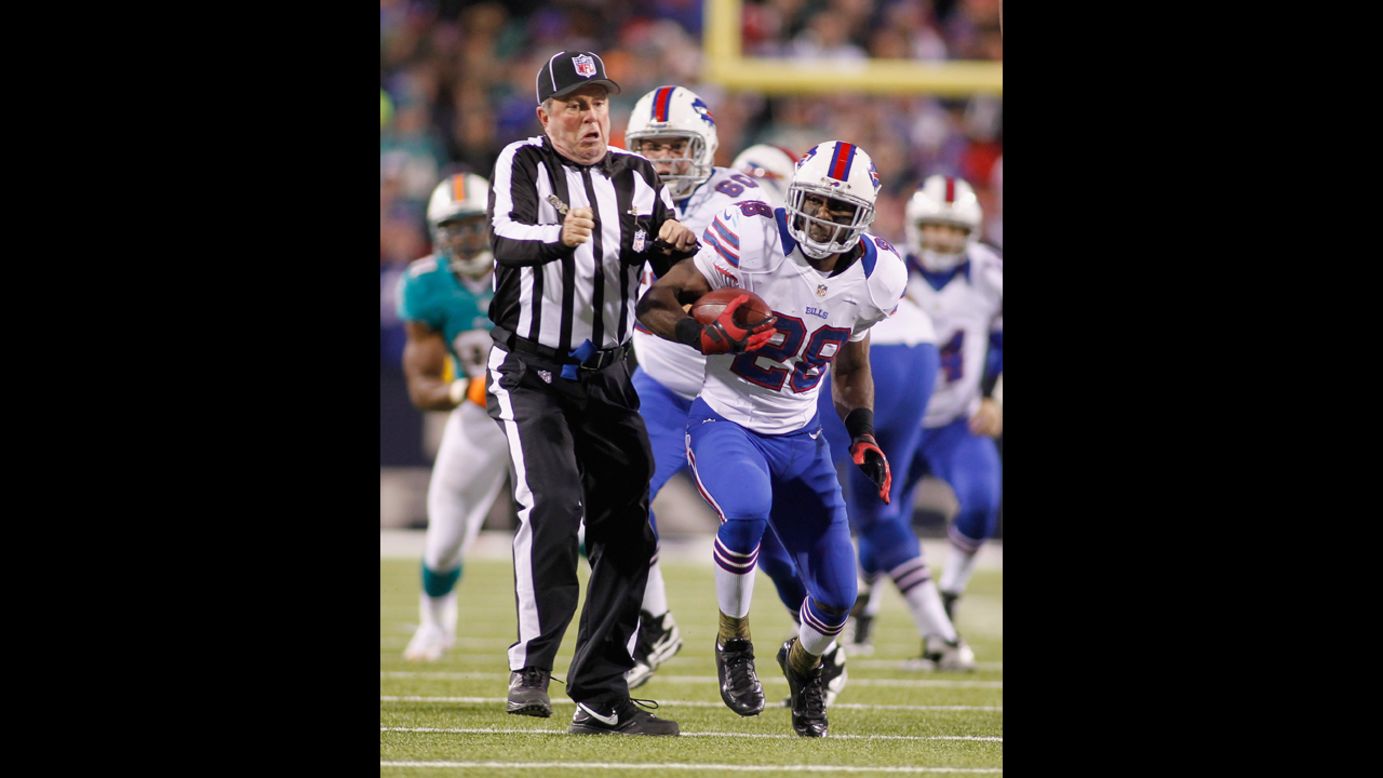 Buffalo's C.J. Spiller bumps umpire Jeff Rice on a run against the Miami Dolphins.