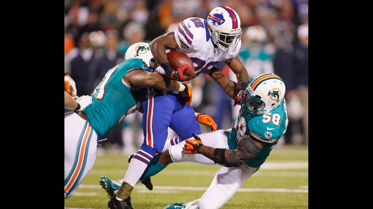 C.J. Spiller of the Buffalo Bills runs against Cameron Wake, left, and Karlos Dansby of Miami.