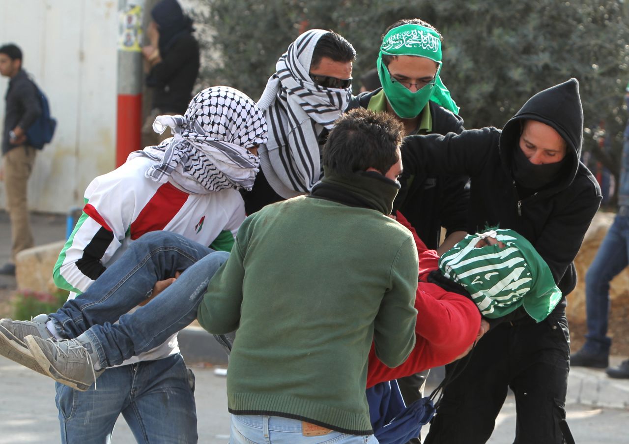 An injured student from the University of Birzeit is carried away Saturday, November 17, during clashes with Israeli soldiers as hundreds of students took part in a demonstration against the ongoing Israeli military offensive on the Gaza Strip in the Israeli occupied West Bank town of Betunia. Israeli strikes on Gaza killed 10 Palestinians and destroyed the Hamas government headquarters.