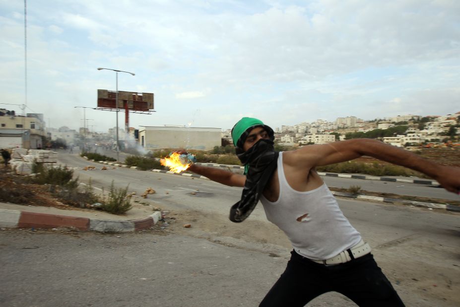 A student from the University of Birzeit throws a molotov cocktail toward Israeli soldiers during clashes.