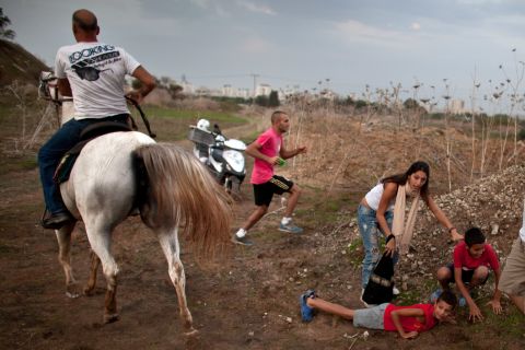 Israeli civilians run for cover during a rocket attack launched from Gaza on November 17 in Tel Aviv, Israel.