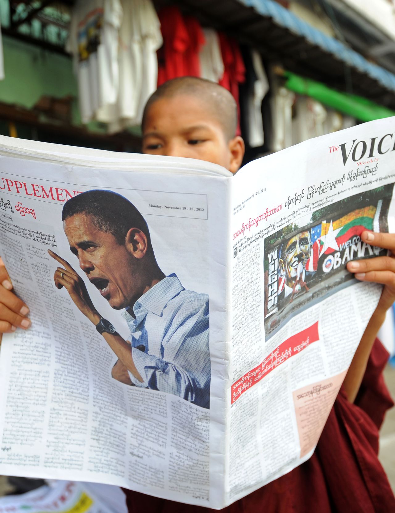 A Buddhist Monk reads a local newspaper carrying a picture of U.S. President Obama in downtown Yangon on Saturday.