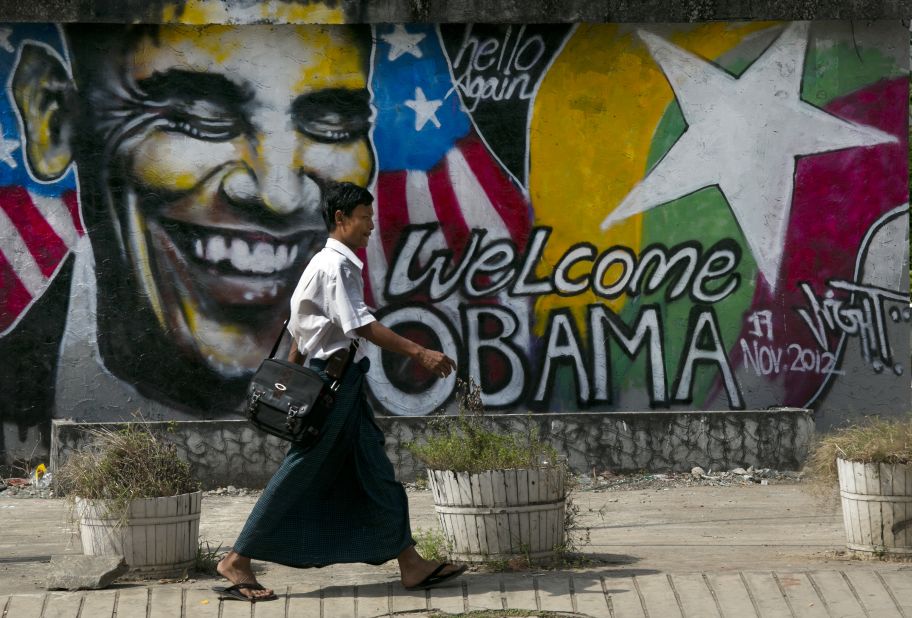 A Burmese man walks by graffiti depicting the U.S. president on Saturday in Yangon.