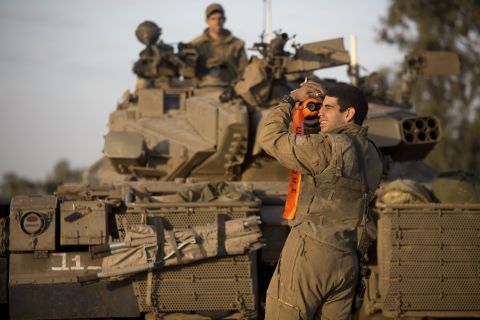 An Israeli soldier from a tank squadron adjusts the tank barrel at an Israeli army deployment area on Sunday, November 18.