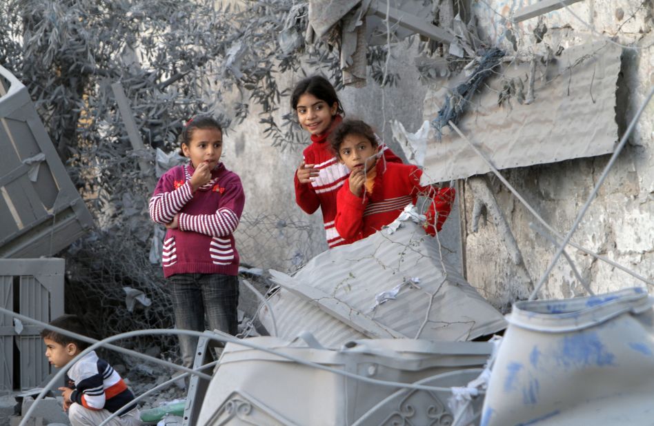 Palestinian children look at damaged buildings following Israeli air strikes Sunday, November 18, in Rafah.