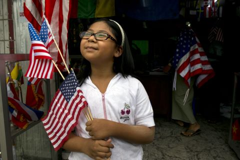 A girl holds American flags that she just purchased at a flag shop as Yangon, Myanmar, prepares for Obama's visit.  Obama will be the first U.S. president to visit Myanmar, also known as Burma, during his four-day tour of Southeast Asia, which will also include visits to Thailand and Cambodia.