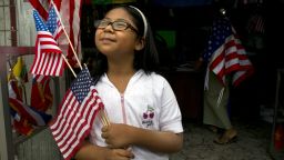 YANGON, MYANMAR - NOVEMBER 18: A Burmese girl holds American flags that she just purchased at a local flag shop as Yangon gets prepared for the first visit of President Barack Obama November 18, 2012 in Yangon, Myanmar.  Barack Obama will become the first US President to visit Myanmar during his four-day tour of Southeast Asia that will also include visits to Thailand and Cambodia. (Photo by Paula Bronstein/Getty Images)