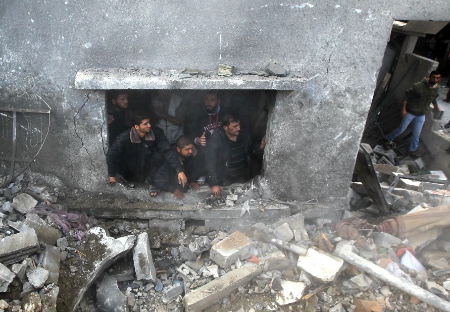 Palestinians search the debris of the home following an Israeli airstrike in Gaza City on Sunday, November 18.