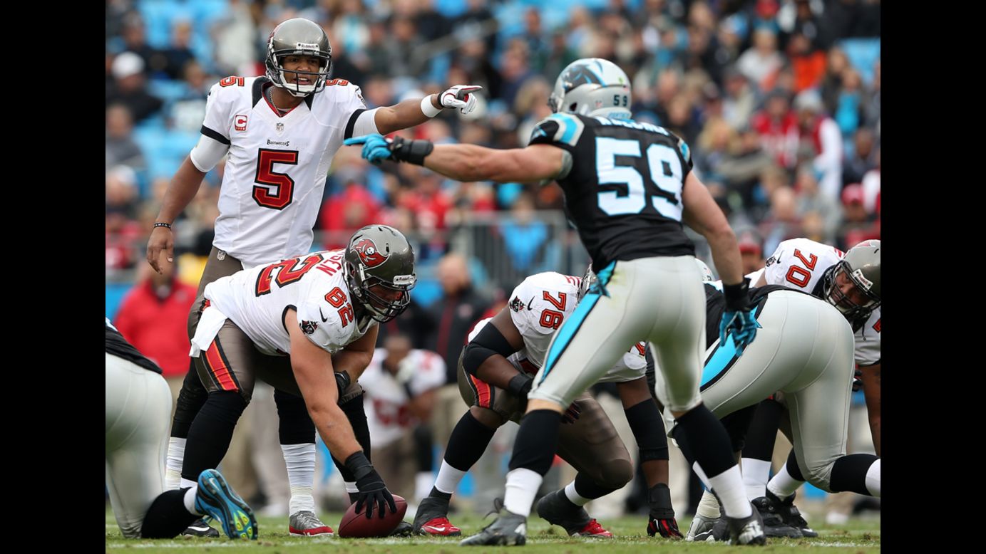 Josh Freeman of the Buccaneers points across the line as Luke Kuechly of the Panthers points on Sunday.