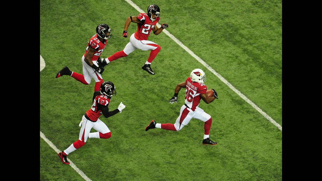LaRod Stephens-Howling of the Cardinals carries the ball against No. 22 Asante Samuel, No. 25 William Moore and No. 27 Robert McClain of the Falcons on Sunday.