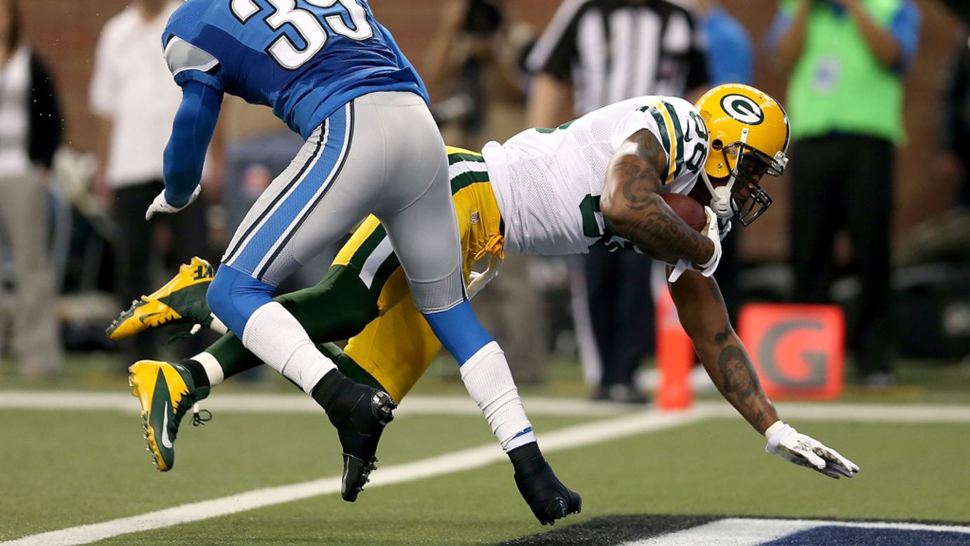 Jermichael Finley of the Packers crosses the goal line against Ricardo Silva of the Lions on Sunday.