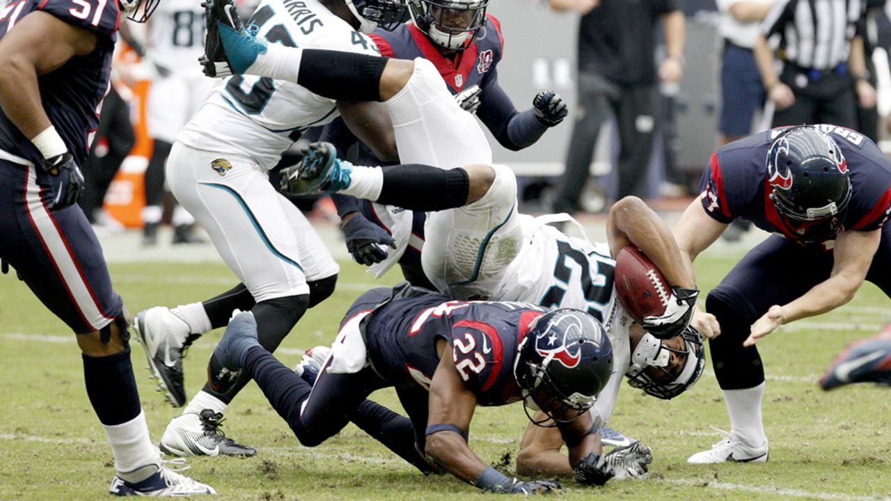 Rashad Jennings of the Jaguars is upended by Alan Ball of the Texans on Sunday.