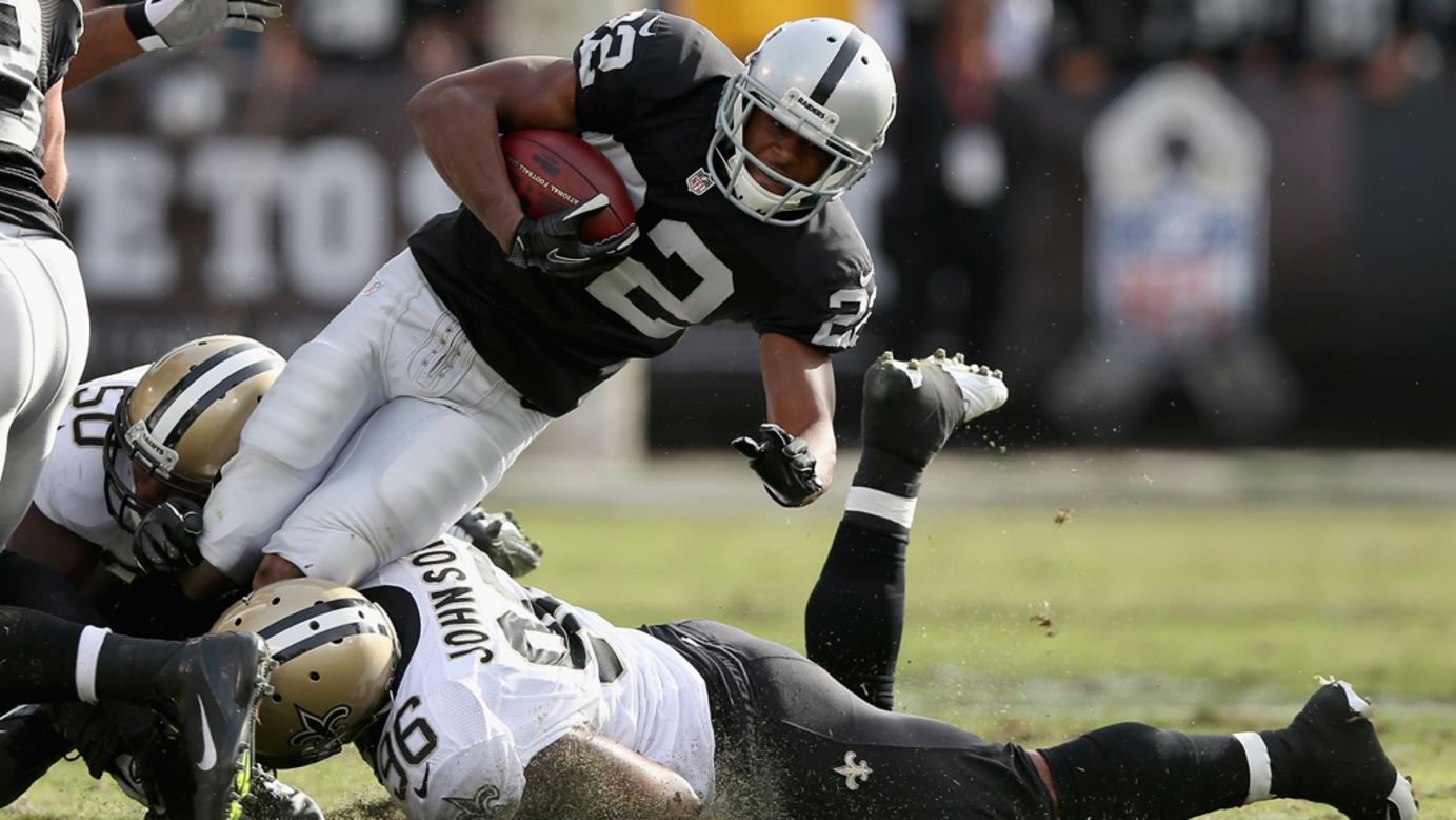 Taiwan Jones of the Raiders is tackled by Tom Johnson of the Saints on Sunday.