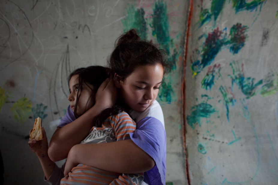 An Israeli girl holds her sister as they take cover in a large concrete pipe used as a bomb shelter during a rocket attack from the Gaza Strip on Monday in Nitzan, Israel.