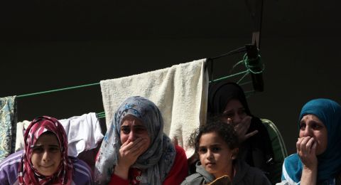 Palestinian women mourn during the funeral Monday of members of one family killed when an Israeli missile struck a three-story building in Gaza City on Sunday.