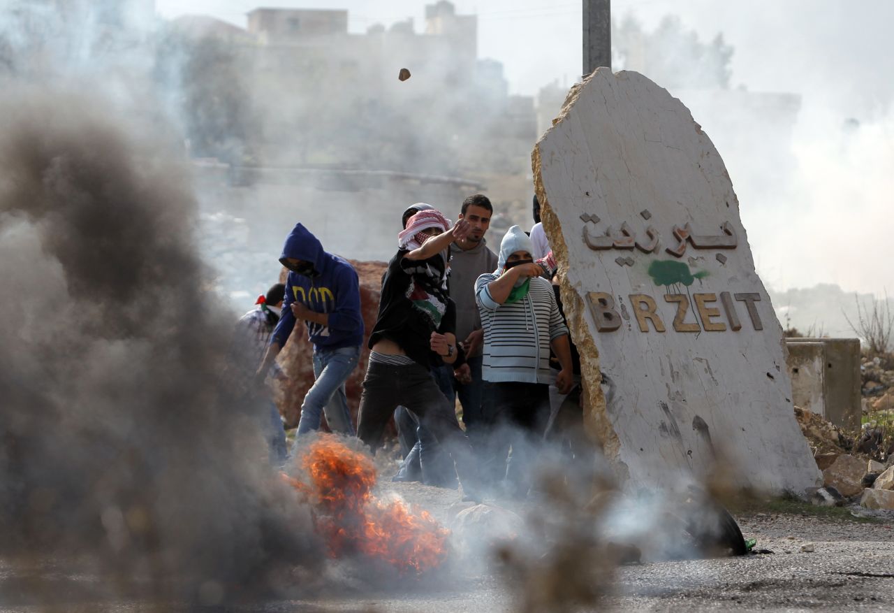 Birzeit University students clash with Israeli soldiers at the Atara checkpoint close to the West Bank university as they protest against Israel's military action on Monday.