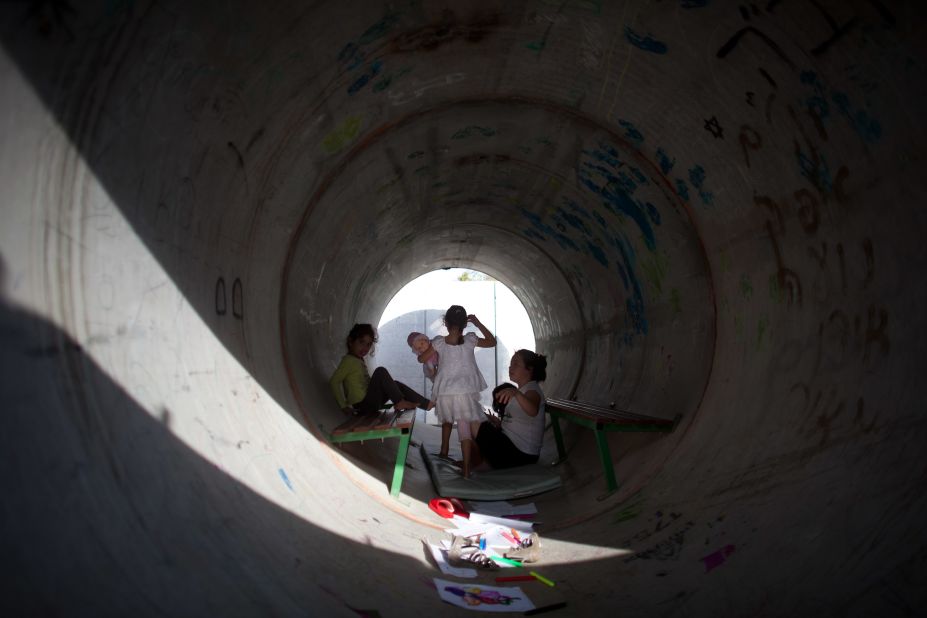 Israeli children play in a large concrete pipe used as a bomb shelter on Monday in Nitzan.