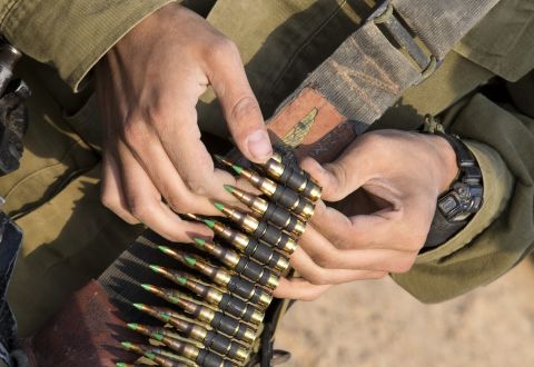 Israeli soldiers from a tank squadron prepare ammunition at an Israeli army deployment area on Monday. 