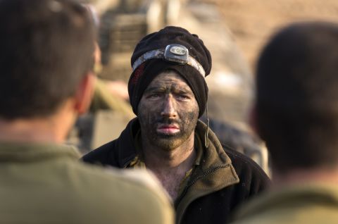 An Israeli soldier from a tank squadron attends a morning briefing at an Israeli army deployment area near the Israel-Gaza Strip border on  Monday. 