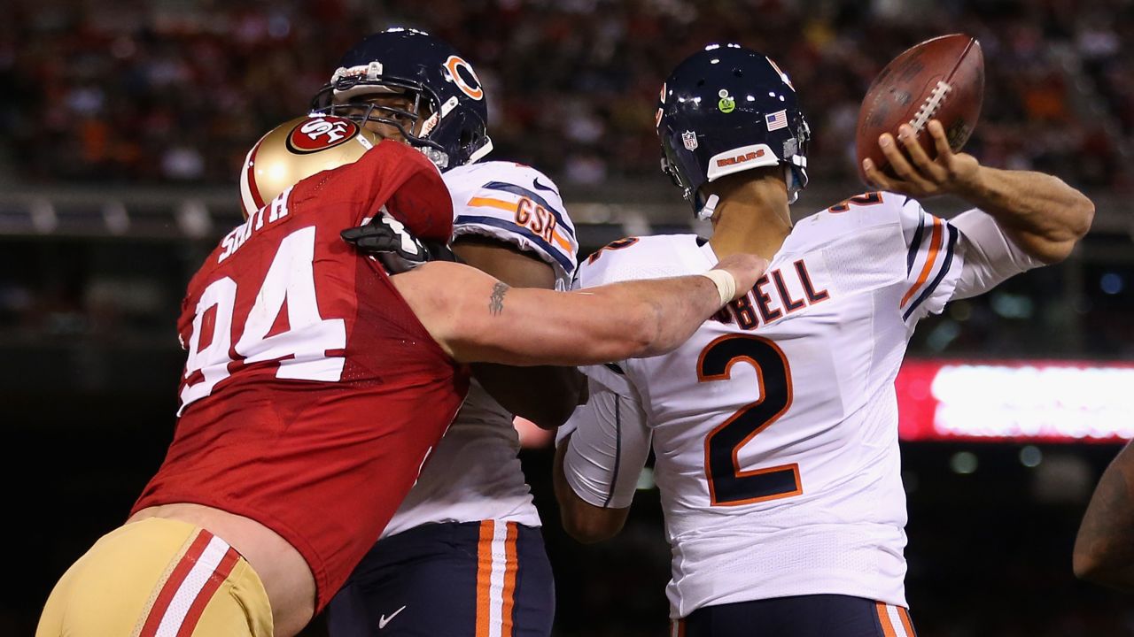 Justin Smith of the 49ers grabs the jersey of Bears quarterback Jason Campbell as he tries to pass the ball Monday.