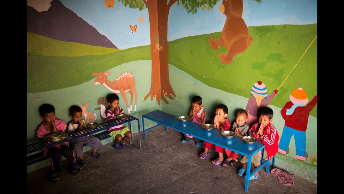 Children at the Butterfly Home say a prayer before eating lunch. Dozens of children live at the home with Basnet and some of her staff members.