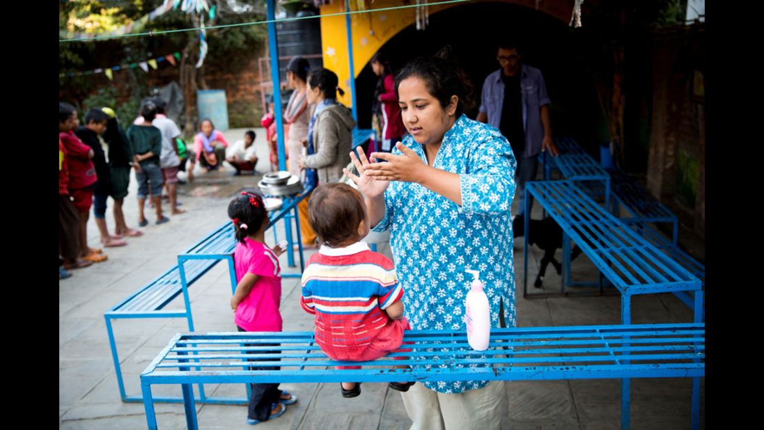 Basnet applies moisturizer cream to one of the children in Kathmandu.