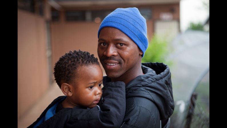 Madondo holds his son at the Kliptown center.