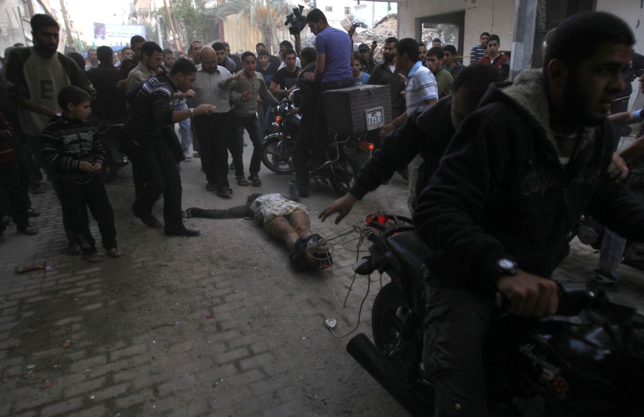 <strong>November 20:</strong> Men on motorcycles drag the body of a man through the streets of Gaza City. The men dragging the body claimed it was the body of a collaborator and an Israeli spy. Hamas and Israel agreed to a cease-fire on November 21 after eight days of round-the-clock warfare.