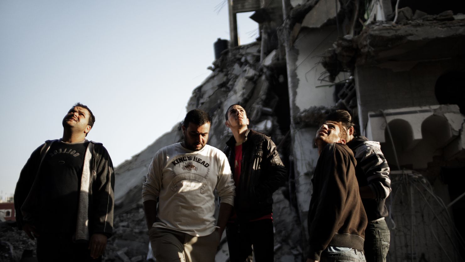 Palestinians stare at a house destroyed by an Israeli airstrike on Gaza City on November 20, 2012. 