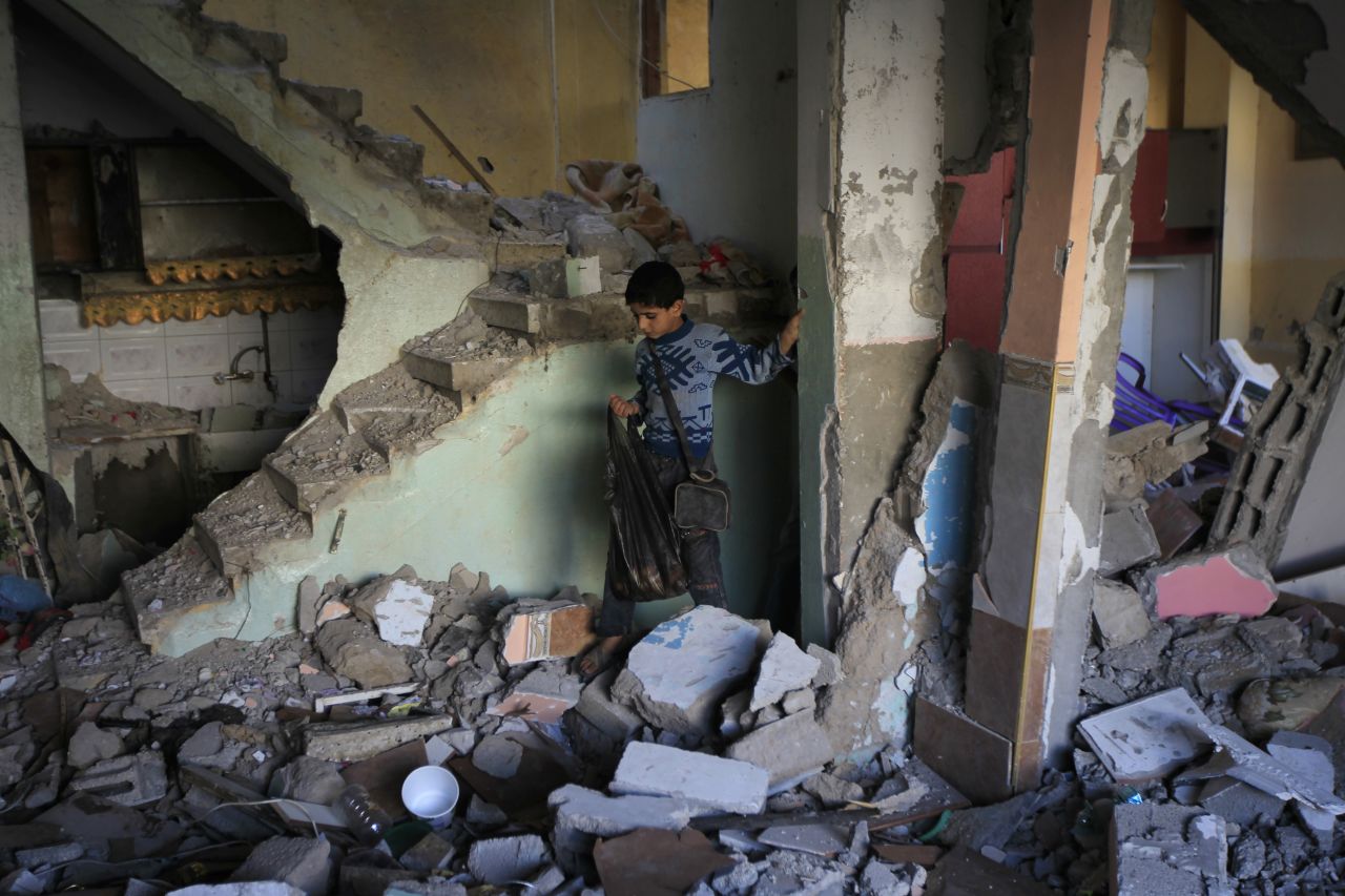 A Palestinian boy walks through the rubble of Hamas commander's house Tuesday in the southern Gaza town of Rafa. An overnight Israeli airstrike targeted the home.