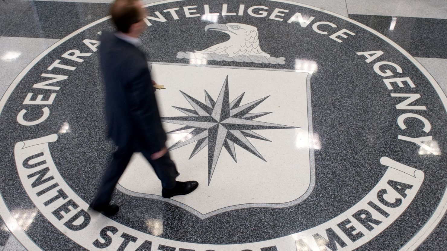A man crosses the CIA logo in the lobby of the agency's headquarters in Langley, Virginia.