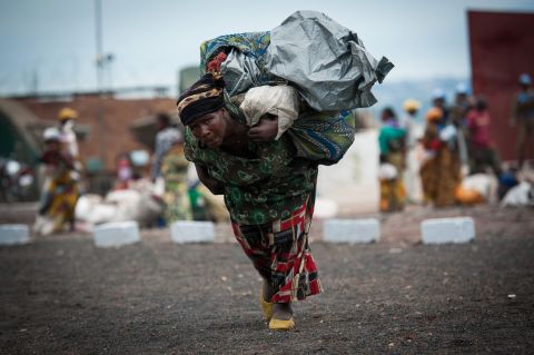 A displaced Congolese woman carries her belongings as she enters a United Nations base in Monigi, 5km from Goma on November 18, 2012.