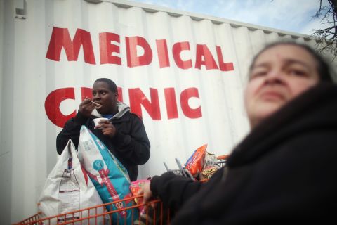 Wilma Marrero and son Joseph Kendall wait in line about five hours Tuesday for food and other items from a Coney Island distribution point in Brooklyn, New York.