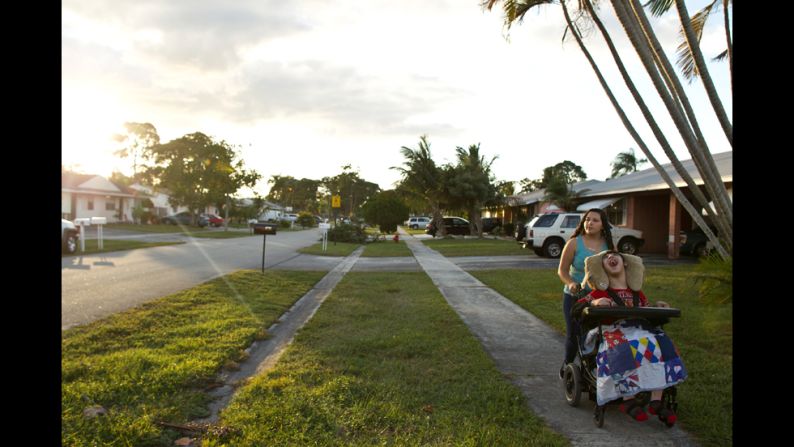 Mandy "Mimi" Alvarado walks her brother Isaac Santiago around their neighborhood in Greenacres, Florida. Isaac uses a wheelchair, but his older sister takes him to the park next to their home and around their neighborhood.