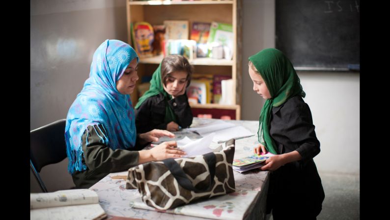 A teacher at the school corrects a girl's homework.