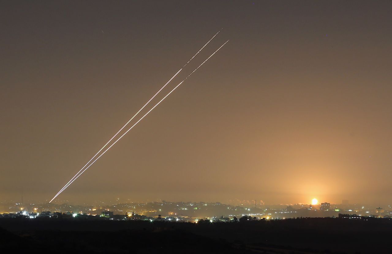 Rockets launch from Gaza City as an explosion is seen on the horizon at Israel's border with Gaza on Wednesday. 