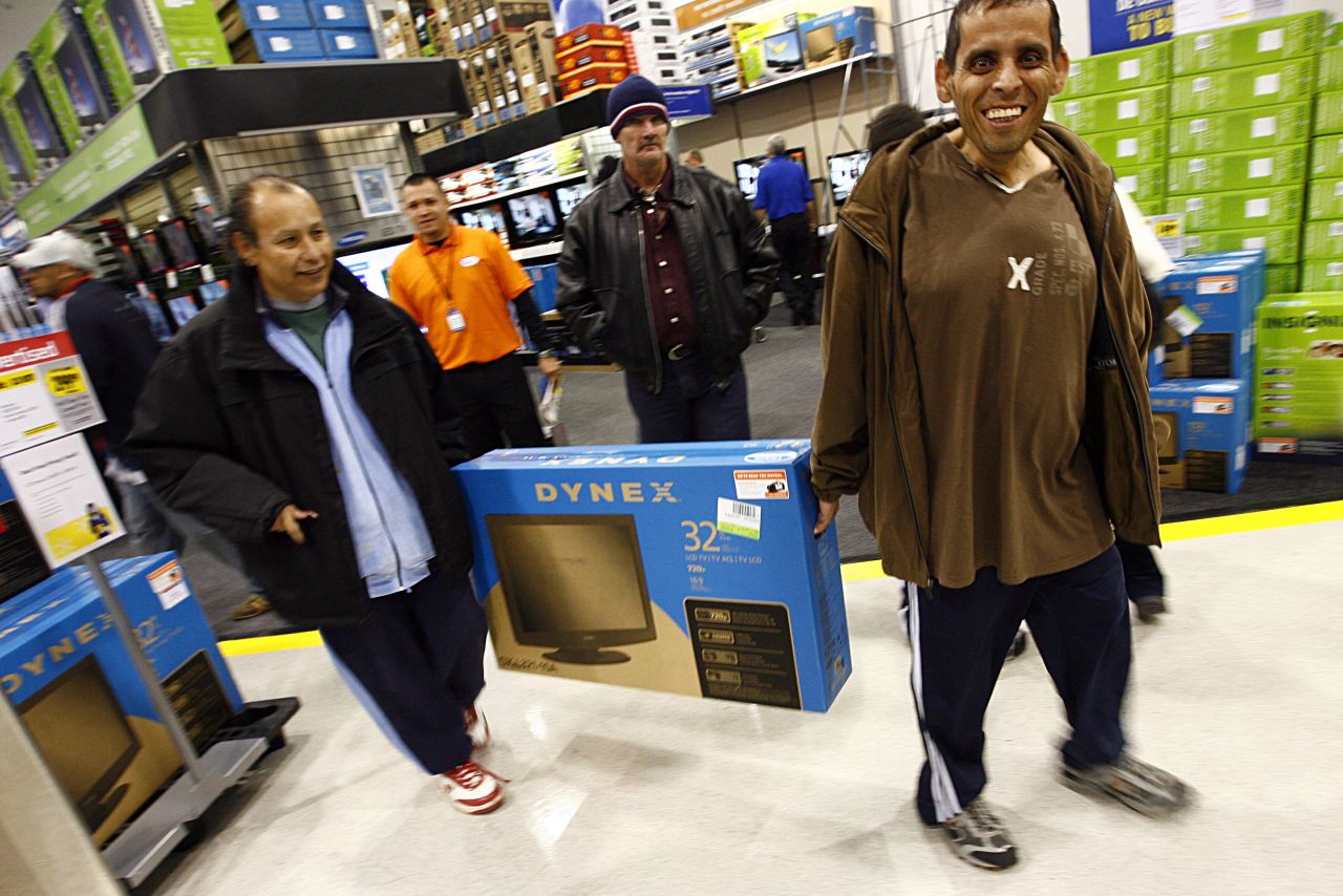 Customers in a Fort Worth, Texas, Best Buy gleefully carry off their Black Friday flatscreen TV score in 2009.
