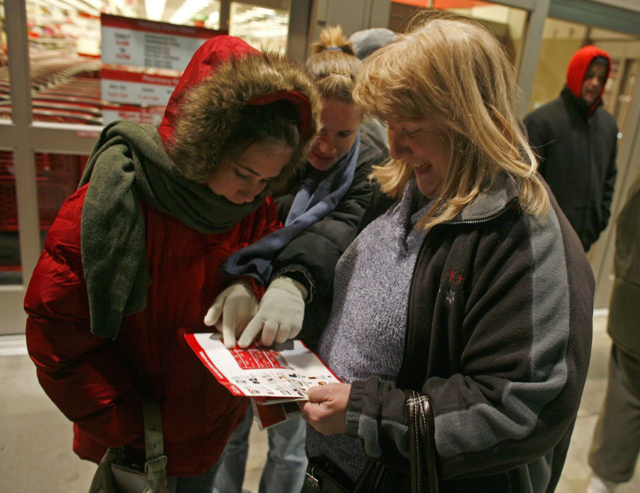 Jean Menarek, right, and her daughters Kayla and Deanna brave the cold Pleasant Prarie, Wisconsin temperatures on November 28, 2008 as they go over Target's Black Friday deals.
