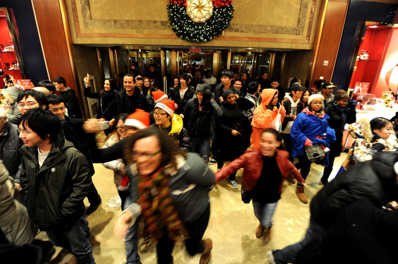 Black Friday shoppers gleefully rush through the doors of the New York City Macy's after it opened its doors at midnight on November 25, 2011.