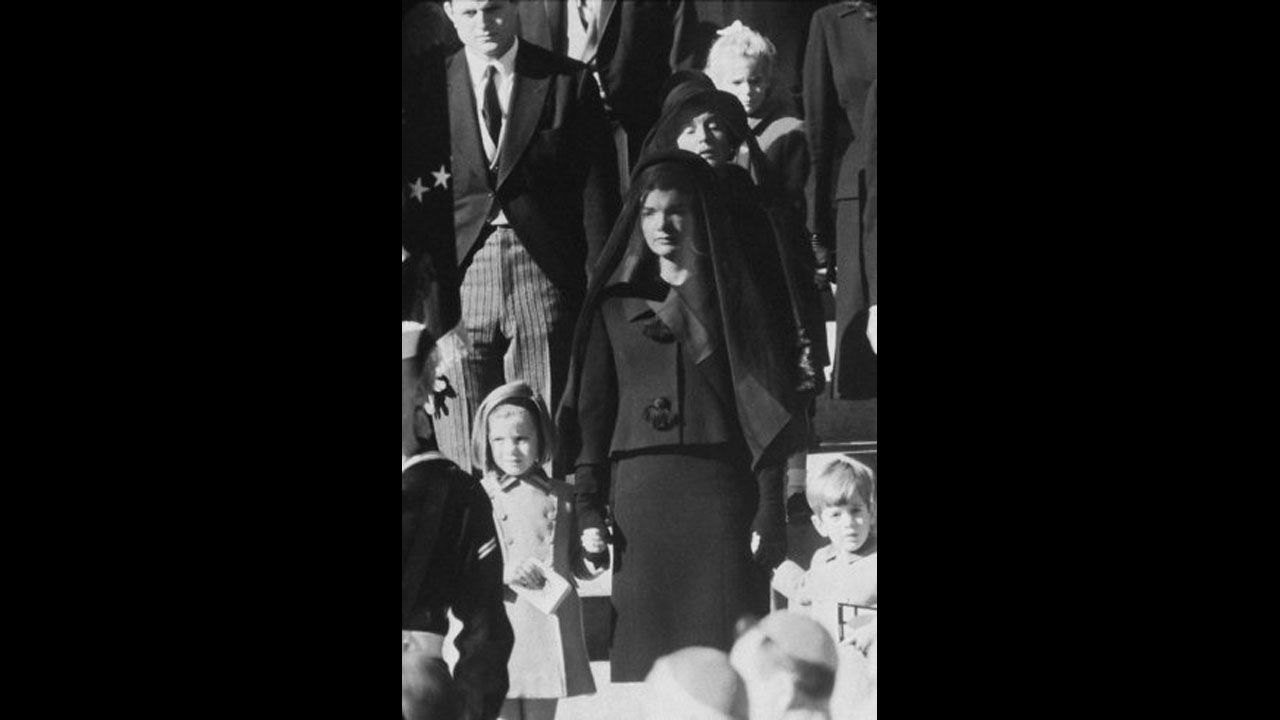 On November 22, 1963, President John F. Kennedy was assassinated while in a presidential motorcade in Dallas. Pictured, Kennedy's widow, Jacqueline Kennedy, children, Caroline and John, and mother, Rose Kennedy, behind, wait outside St. Matthew's Cathedral for the procession to the cemetery during his funeral on November 25. 