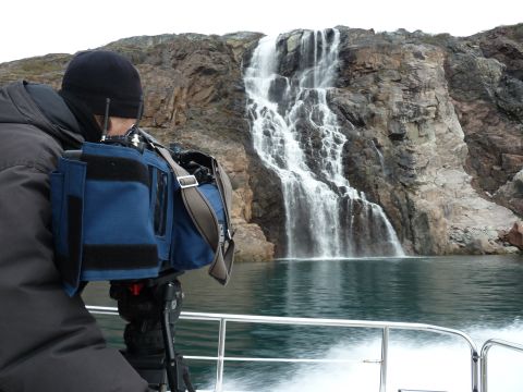 CNN camera woman Claudia Otto films a waterfall. There is enough water for farming in Greenland, using it for irrigation remains a problem.