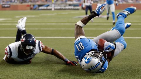 Calvin Johnson of the Detroit Lions makes a touchdown catch next to Alan Ball of the Houston Texans.