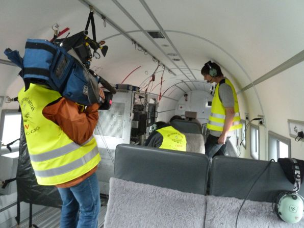 Geophysicist Daniel Steinhage, the head of the mission to Greenland, and his crew outfit the plane with state of the art computers. CNN camera woman Claudia Otto films the scientists. 