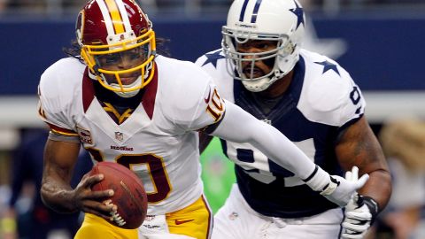 Redskins quarterback Robert Griffin III scrambles with the ball before being sacked by Jason Hatcher of the Cowboys.