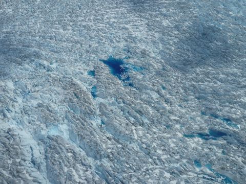 Meltwater ponds below indicate surface melt during the arctic summer. 