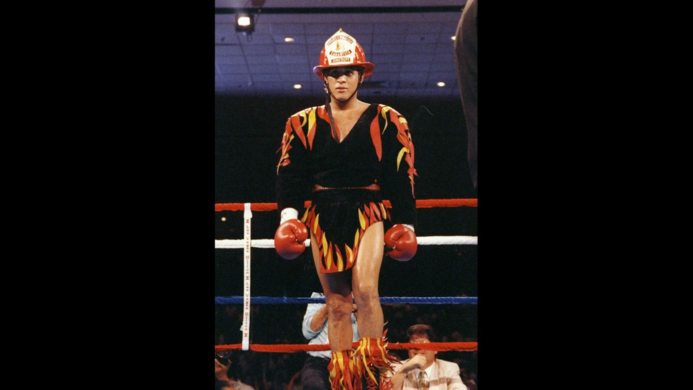 Before his 1992 fight against Eddie Van Kirk, Camacho stands in the ring wearing a firefighter hat and an outfit adorned with flames.
