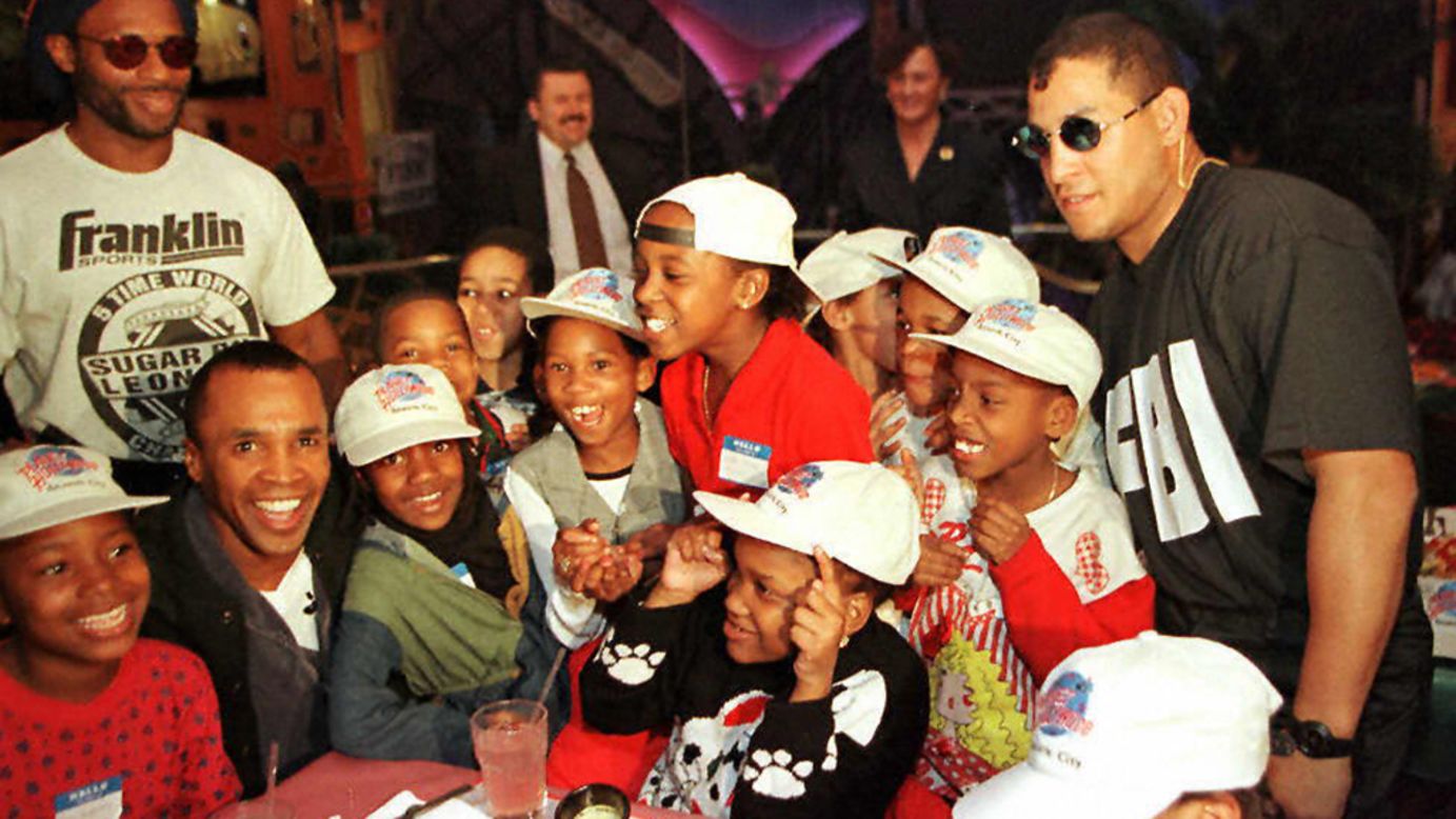 Boxers Sugar Ray Leonard, sitting second from left, and Hector Camacho, right, pose with kids from a New Jersey school during a benefit luncheon at Planet Hollywood in Atlantic City on February 28, 1997.